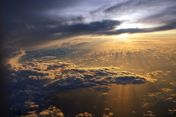 منظره شگفت انگیز از هواپیما در طلوع خورشید و ابرها