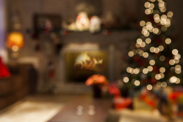 صحنه کریسمس با هدایای درخت و آتش در پس زمینه