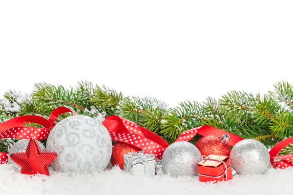 بابل های کریسمس و روبان قرمز با درخت صنوبر برفی جدا شده در پس زمینه سفید با کپی sp