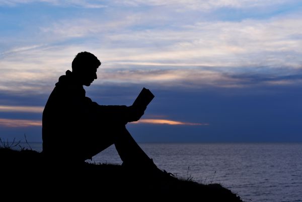 شبح انسان در حال خواندن در غروب آفتاب نور دریا اقیانوس طبیعت