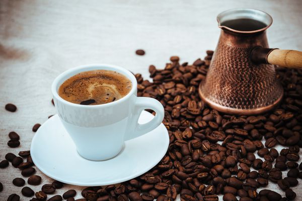 قهوه ترک و فنجان قهوه در پس زمینه کرفس دانه های قهوه جدا شده در پس زمینه سفید دانه های قهوه برشته شده