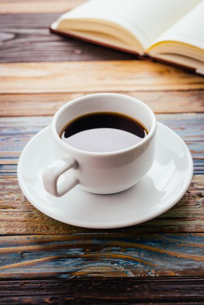 فنجان قهوه در پس زمینه چوبی - جلوه قدیمی