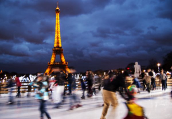 پاریس فرانسه - 29 دسامبر 2012 برج ایفل نورانی و مردمی روی پیست یخ تار و بدون تمرکز برج ایفل با بیش از 7 میلیون بازدید کننده در سال پربازدیدترین بنای تاریخی جهان است