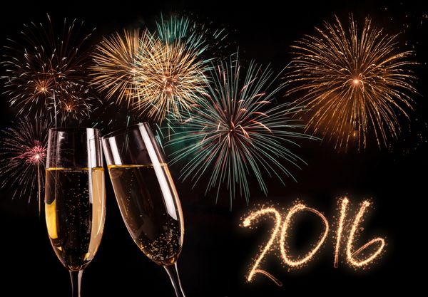 یک جفت فلوت شامپاین و آتش بازی در پس زمینه مفهوم سال جدید 2016