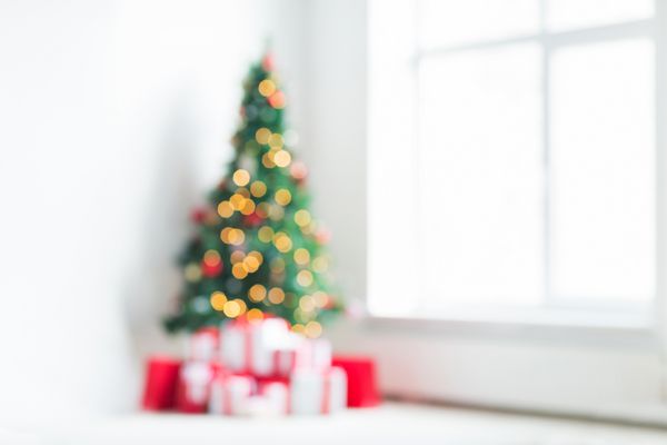 تعطیلات جشن و مفهوم خانه - اتاق نشیمن با پس زمینه درخت کریسمس و هدیه