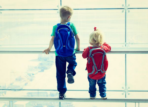 پسر کوچک و دختر نوپا به هواپیما در فرودگاه نگاه می کنند بچه ها سفر می کنند
