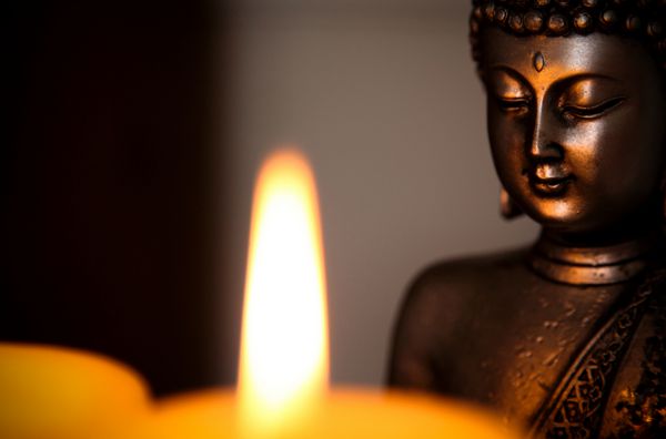 مجسمه بودا و نور شمع