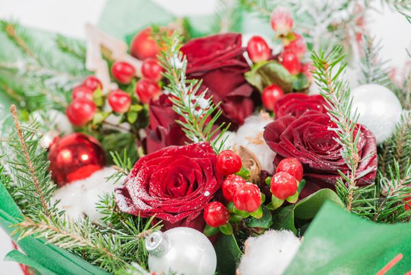 نمای نزدیک از دسته گل کریسمس با گل و صنوبر با برف دف کم عمق