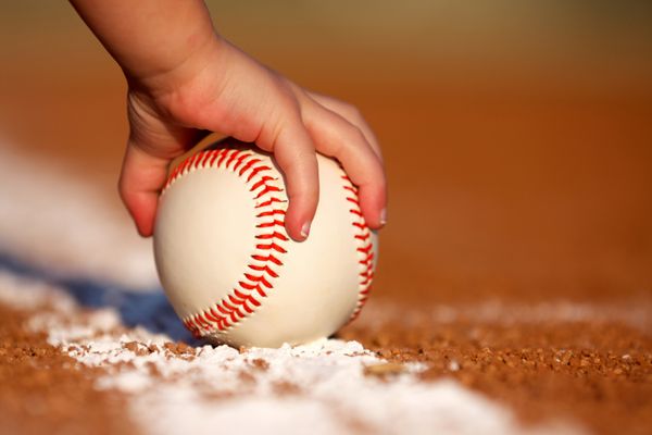 دست کودک در حال گرفتن توپ بیسبال