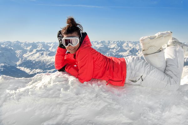 اسکی باز زن در بالای کوه های آلپ اروپایی با پس زمینه کوه