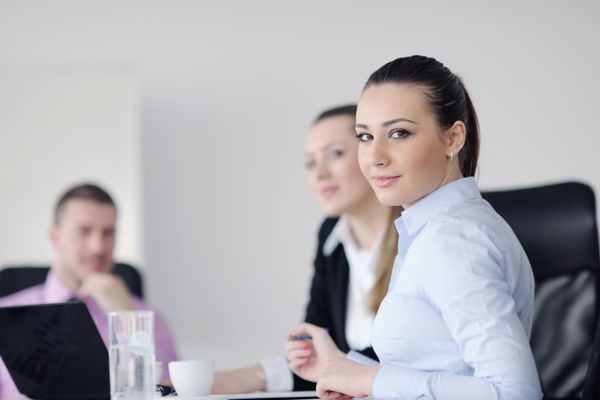 تیم افراد تجاری در یک جلسه در یک محیط اداری سبک و مدرن