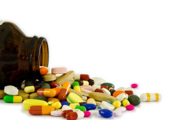 بسیاری از انواع قرص های دارویی کپسول ها و منفذ دارویی از بطری با زمینه سفید جدا شده برای ساخت مفهوم صنعت سلامت استفاده می شود