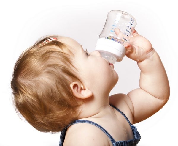 کودک دوست داشتنی در حال نوشیدن از بطری دختر 10 ماهه