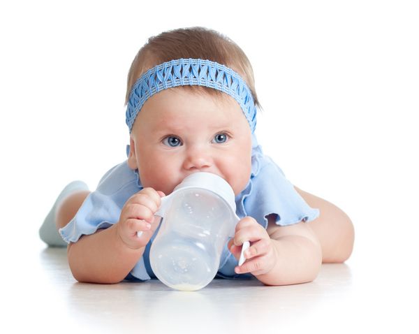 دختر بچه زیبا در حال نوشیدن شیر از شیشه 8 ماهه