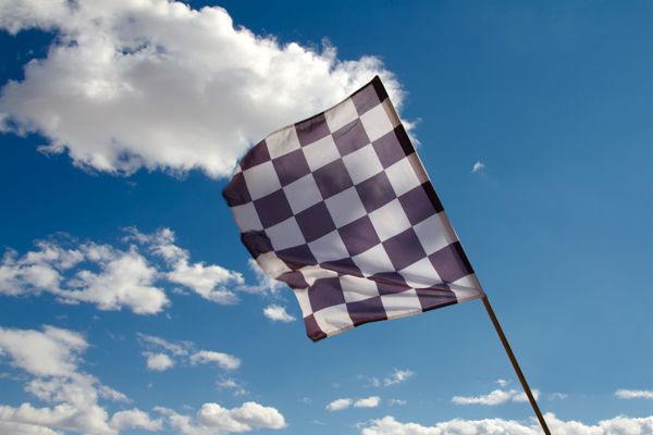 پرچم شطرنجی در برابر آسمان آبی با ابرها
