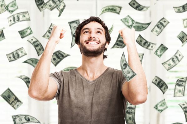 پرتره یک مرد جوان بسیار شاد در بارانی از پول