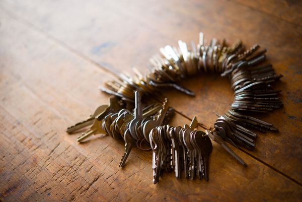 بسیاری از کلیدهای قدیمی روی یک میز چوبی قدیمی که به خوبی استفاده شده است