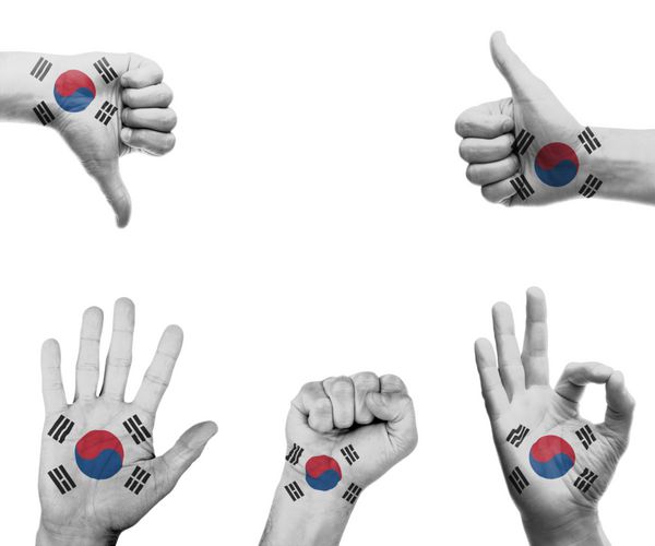 مجموعه ای از دست ها با حرکات مختلف در پرچم کره جنوبی پیچیده شده است
