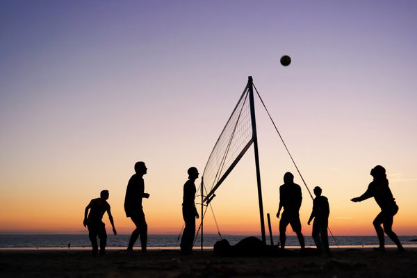شبح های یک گروه از جوانان والیبال ساحلی در ساحل در بریتنی فرانسه