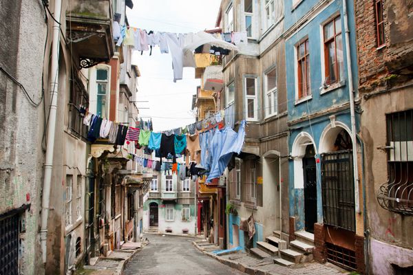 استانبول ترکیه - 15 ژانویه خشک کردن لباس های تمیز روی طناب بین خانه های قدیمی خیابان باریک منطقه ترلباسی در 15 ژانویه 2012 استانبول در مساحت 5343 کیلومتر مربع با جمعیت واقع شده است 13483052