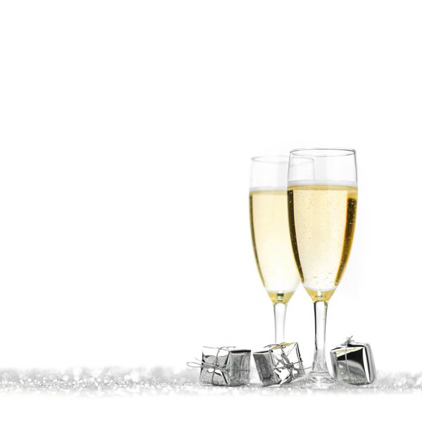 لیوان شامپاین و هدایای نقره ای در پس زمینه زرق و برق