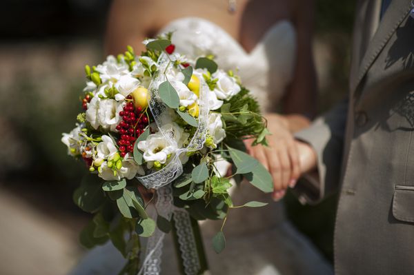 دسته گل عروسی از رنگ های لطیف در دستان تازه عروس