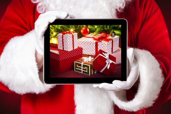 بابا نوئل تبلتی با هدایای کریسمس در دست دارد