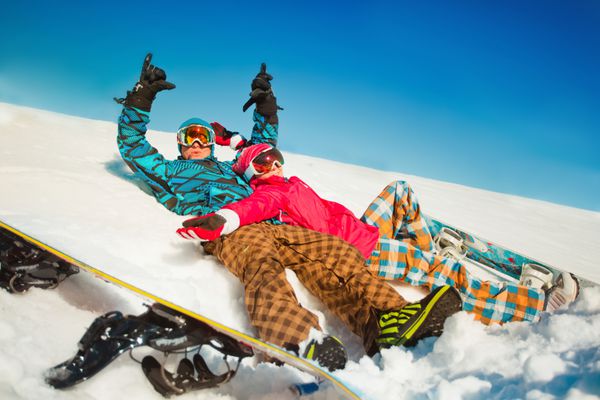 دختر و پسر با اسنوبرد روی برف