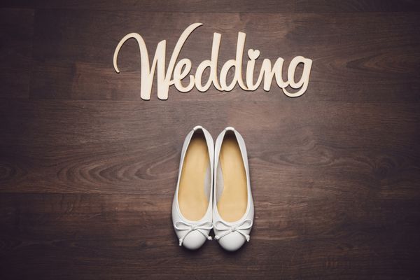 عروسی حروف چوبی با کفش عروسی روی زمین چوبی