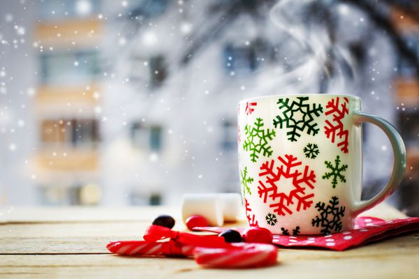 فنجان قهوه در پس‌زمینه پنجره روز زمستانی سرد با پس‌زمینه دنج زمستانی تعطیلات کریسمس عصاهای آب نباتی