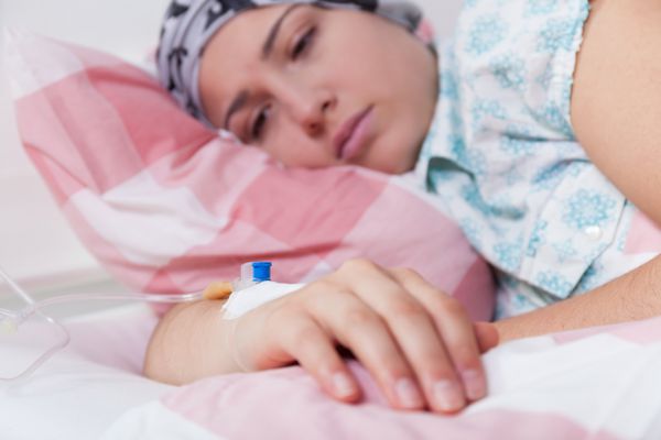 زن بیمار جوان خسته روی تخت بیمارستان دراز کشیده است