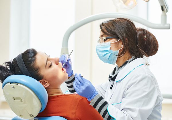 دکتر دندانپزشک آسیایی زن در طول معاینه و درمان دندان
