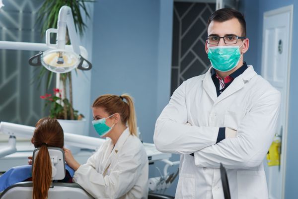 پرتره دکتر خوش تیپ در مطب دندانپزشکی نور روشن و طبیعی