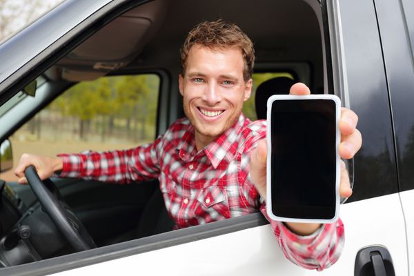مرد تلفن هوشمند در حال رانندگی با ماشین برنامه را روی صفحه نمایش نشان می دهد که لبخند می زند راننده تاکسی مرد با استفاده از برنامه‌های 4g که صفحه لمسی خالی را برای مکان GPS نشان می‌دهد تمرکز بر روی مدل و روی صفحه نمایش برای کپی sp