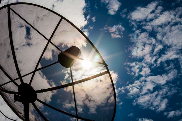 شبکه فناوری ارتباطات ظروف ماهواره ای با خورشید و ابر سفید در پس زمینه