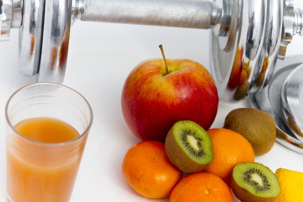 تجهیزات بدنسازی و غذای سالم سیب شلیل کیوی لیمو آب میوه دمبل و نوار اندازه گیری