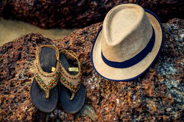 کلاه حصیری و دمپایی در ساحل استوایی تعطیلات در دریا گوا هند
