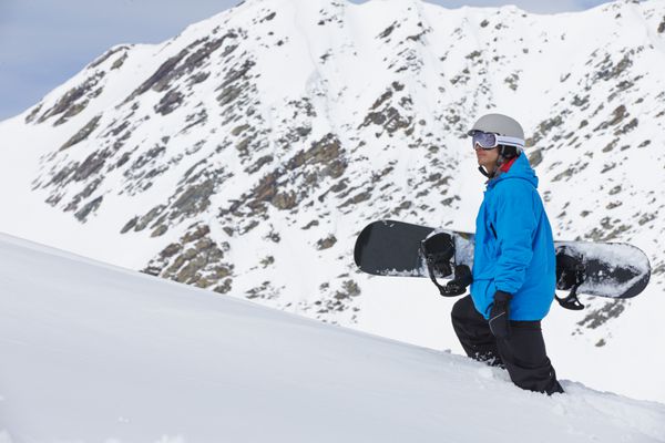 مردی با اسنوبرد در تعطیلات اسکی در کوهستان