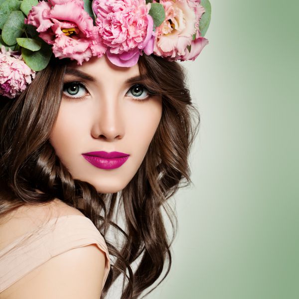دختر زیبا با تاج گل موهای فرفری بلند و آرایش مد پرتره شکوفه زن جوان زیبا با گل های صورتی