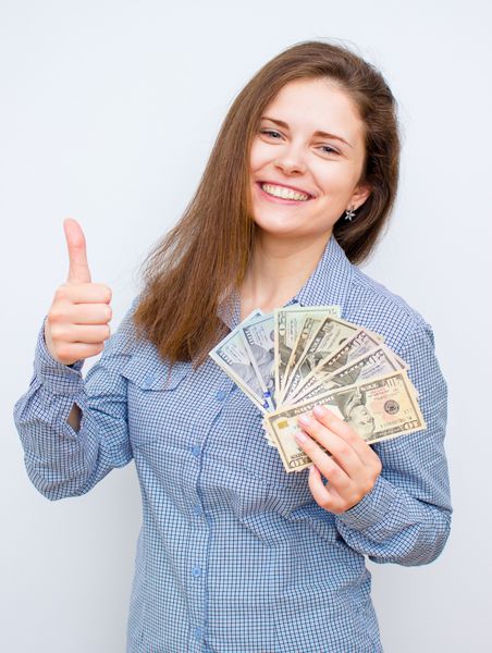 زن جوان با دلار در حال حرکت با انگشت شست بالا