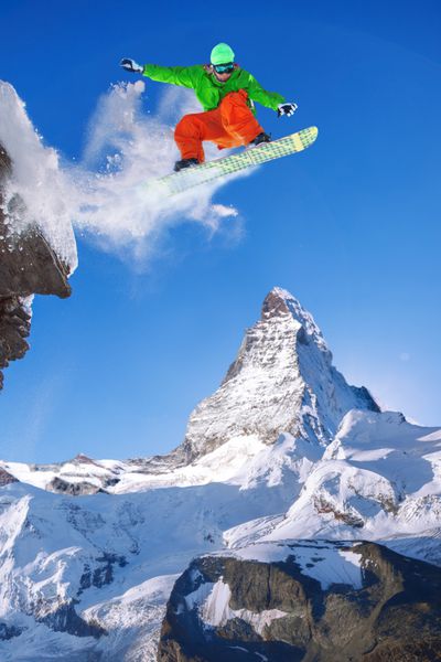 اسنوبوردیست در حال پریدن روی قله ماده هورن در سوئیس