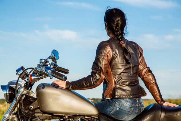 دختر دوچرخه سوار با ژاکت چرمی روی موتور سیکلت