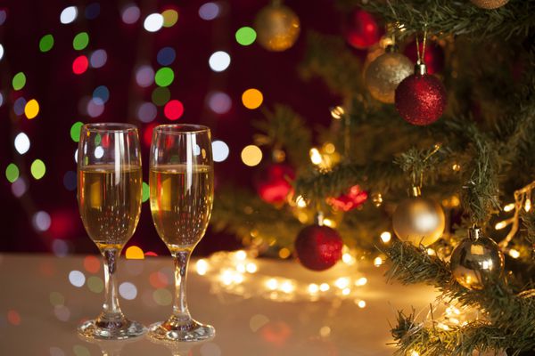 دو لیوان شامپاین در نزدیکی درخت کریسمس زیبا
