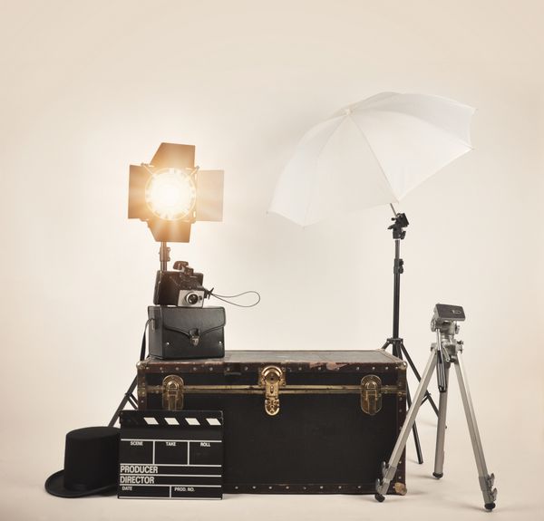 یک دوربین قدیمی قدیمی با نورهای استودیویی و تجهیزات مختلف نورپردازی عکاسی برای یک کارگردان یا فیلم مفهومی