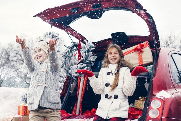 آماده سازی تعطیلات کودکان پیش از نوجوانی از بسیاری از هدایای کریسمس در صندوق عقب ماشین لذت می برند زمستان سرد هوای برفی