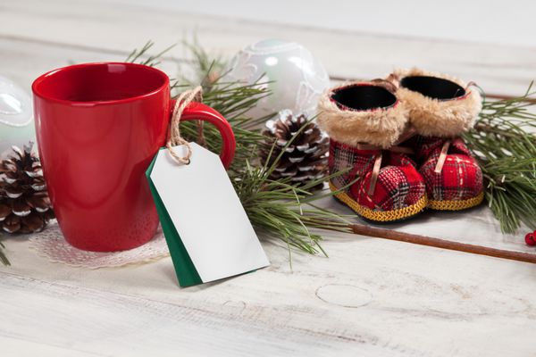 یک فنجان قهوه روی میز چوبی با برچسب قیمت خالی و تزئینات کریسمس مفهوم ماکت کریسمس