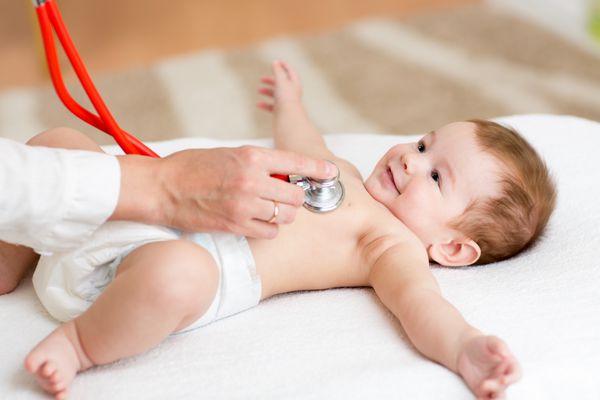 نوزاد پسری که ضربان قلبش را توسط پزشک متخصص اطفال بررسی می کند