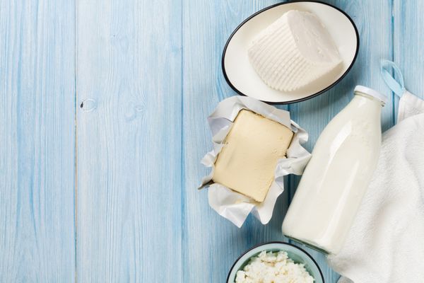 محصولات لبنی روی میز چوبی شیر پنیر پنیر کشک و کره نمای بالا با copy sp