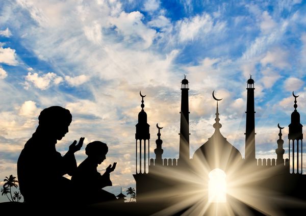 مفهوم دین اسلام شبح دو مرد در حال دعا در پس زمینه تالار شهر در سپیده دم