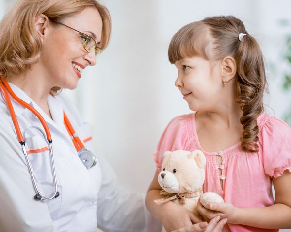 پزشک متخصص اطفال در حال صحبت با بچه